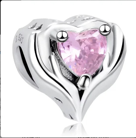 Mano sosteniendo cuentas de dijes de corazón